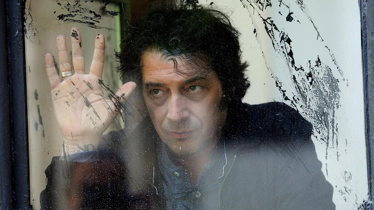 Sandro Veronesi, Schriftsteller, aufgenommen hinter einer schnutzigen Glasscheibe. Sandro Veronesi, Schriftsteller, aufgenommen hinter einer schnutzigen Glasscheibe.