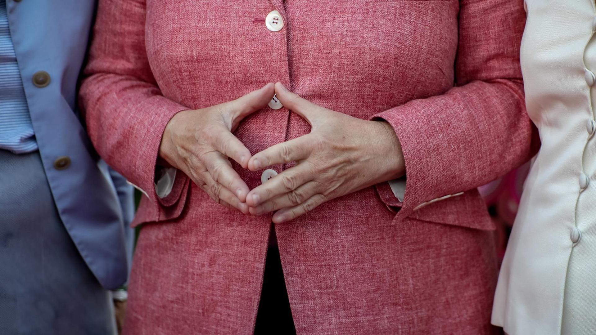 Bundeskanzlerin Angela Merkel hat die Hände zur Raute aneinandergelegt Bundeskanzlerin Angela Merkel hat die Hände zur Raute aneinandergelegt