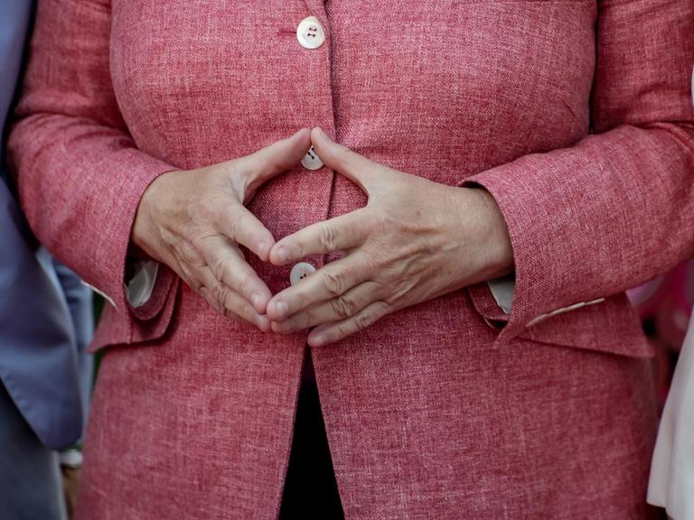 Bundeskanzlerin Angela Merkel hat die Hände zur Raute aneinandergelegt