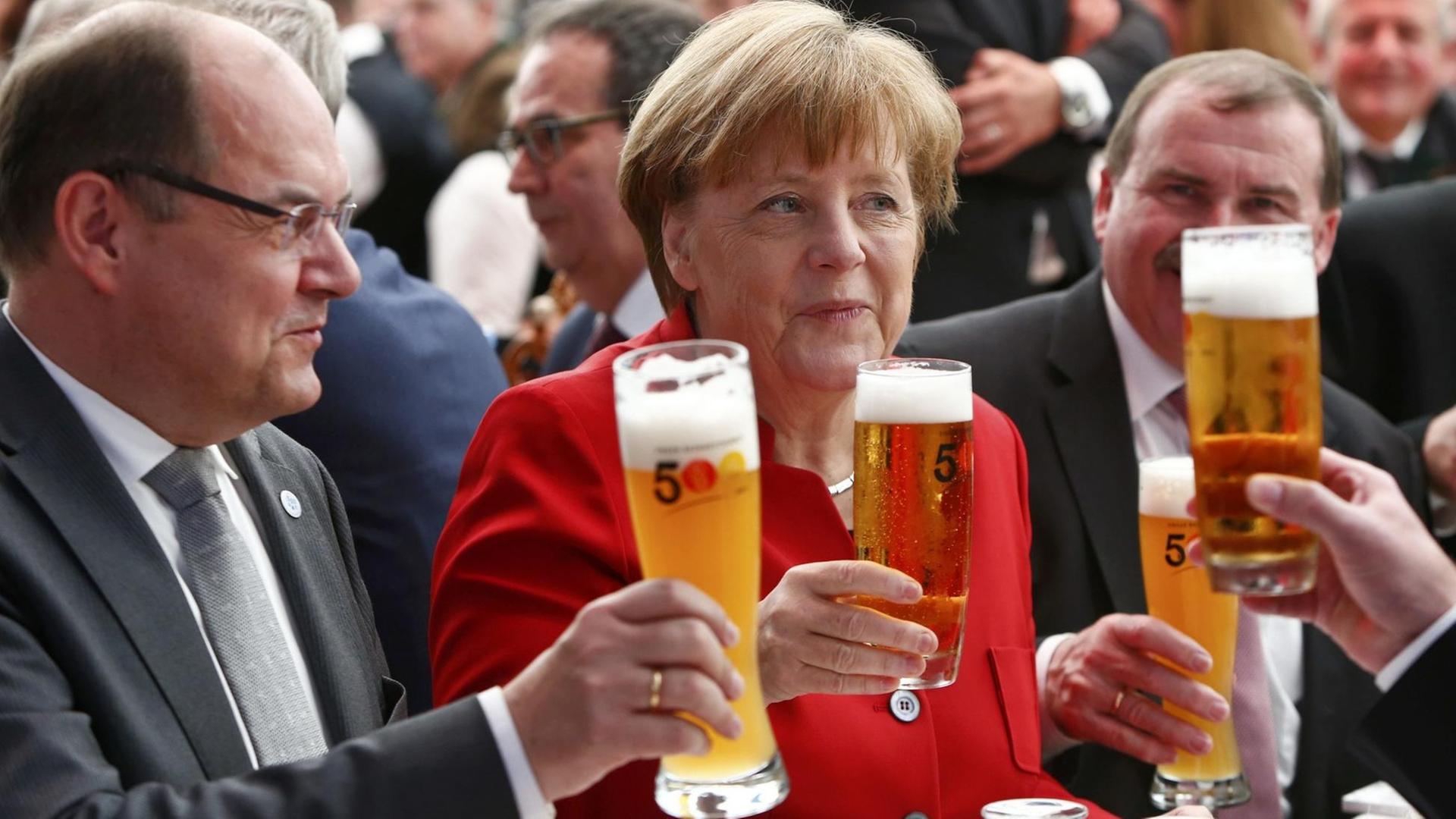 Bundeskanzlerin Angela Merkel hebt am 22.04.2016 in Ingolstadt während des Festaktes zum 500-jährigen Bestehen des Reinheitsgebotes für Bier ein Bierglas hoch. Links meben ihr sitzt Bundeslandwirtschaftsminister Christian Schmidt . Foto: POOL/REUTERS/Michaela Rehle | Bundeskanzlerin Angela Merkel hebt am 22.04.2016 in Ingolstadt während des Festaktes zum 500-jährigen Bestehen des Reinheitsgebotes für Bier ein Bierglas hoch. Links meben ihr sitzt Bundeslandwirtschaftsminister Christian Schmidt . Foto: POOL/REUTERS/Michaela Rehle |