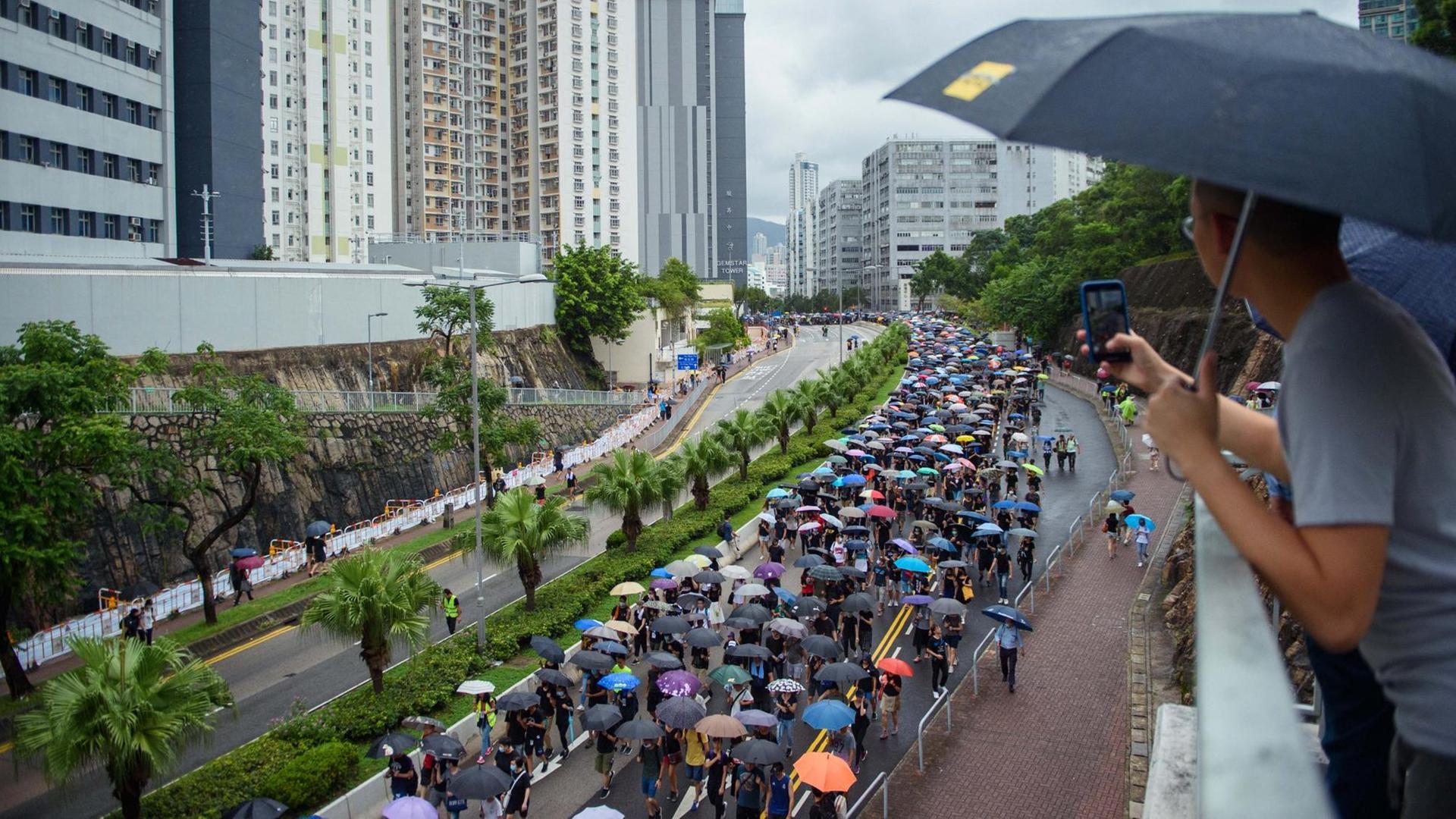 Demonstrantenzug in Hongkong mit Regenschirmen.
