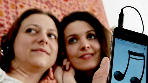 Zwei Frauen hören über ein Smartphone Musik