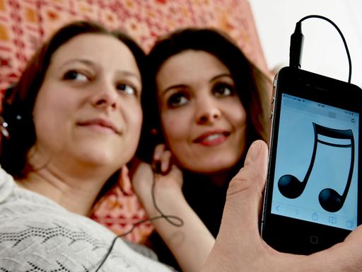Zwei Frauen hören über ein Smartphone Musik