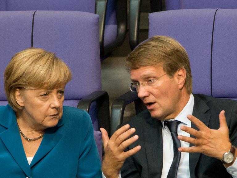 Angela Merkel und Ronald Pofalla diskutieren im Bundestag