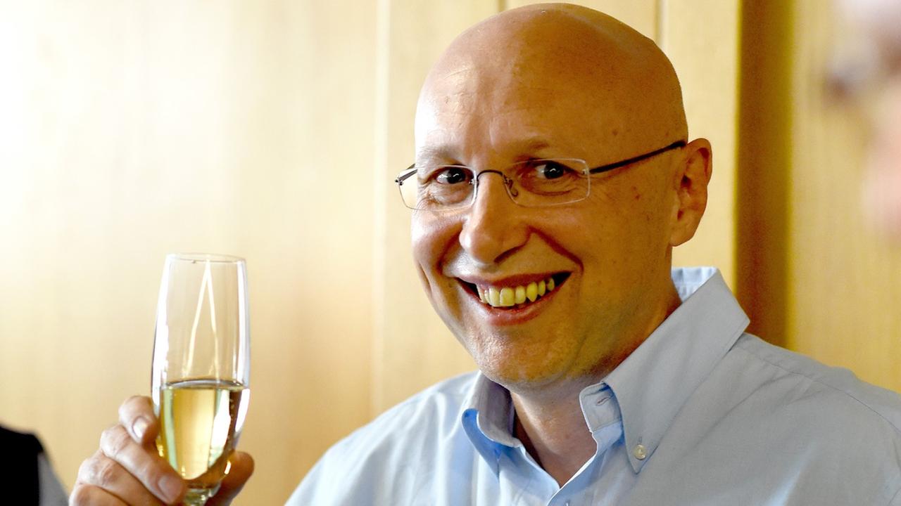 Stefan W. Hell trinkt in Göttingen bei einer kleinen Feier mit seinen Mitarbeitern ein Glas Sekt.