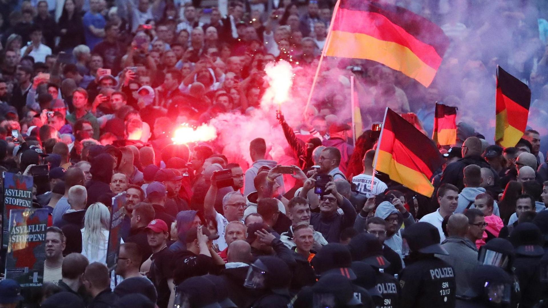 Chemnitz: Demonstranten der rechten Szene zünden Pyrotechnik und schwenken Deutschlandfahnen. Chemnitz: Demonstranten der rechten Szene zünden Pyrotechnik und schwenken Deutschlandfahnen.