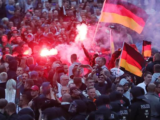 Chemnitz: Demonstranten der rechten Szene zünden Pyrotechnik und schwenken Deutschlandfahnen.