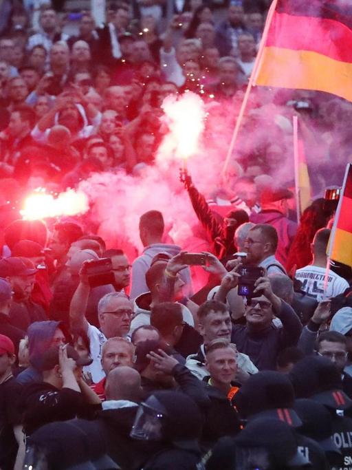 Chemnitz: Demonstranten der rechten Szene zünden Pyrotechnik und schwenken Deutschlandfahnen.