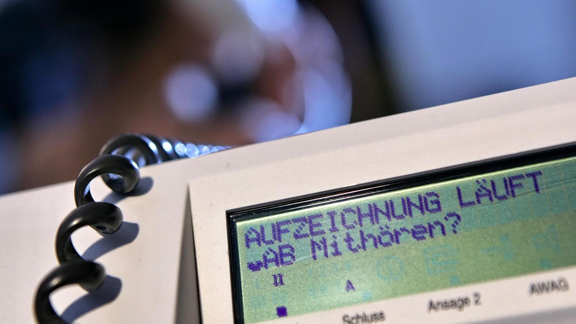 Während im Hintergrund eine Frau telefoniert, wird an einem Telefon der Deutschen Telekom der Schriftzug "Aufzeichnung läuft - Mithören?" angezeigt, aufgenommen am Samstag (31.05.2008) in Hamburg (gestellte Aufnahme - Illustration zum Thema Telefonüberwachung). Foto: Bodo Marks dpa/lno +++(c) dpa - Report+++ | Verwendung weltweit