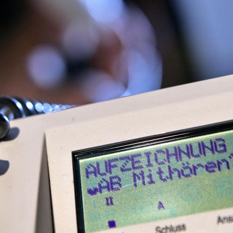 Während im Hintergrund eine Frau telefoniert, wird an einem Telefon der Deutschen Telekom der Schriftzug "Aufzeichnung läuft - Mithören?" angezeigt, aufgenommen am Samstag (31.05.2008) in Hamburg (gestellte Aufnahme - Illustration zum Thema Telefonüberwachung). Foto: Bodo Marks dpa/lno +++(c) dpa - Report+++ | Verwendung weltweit