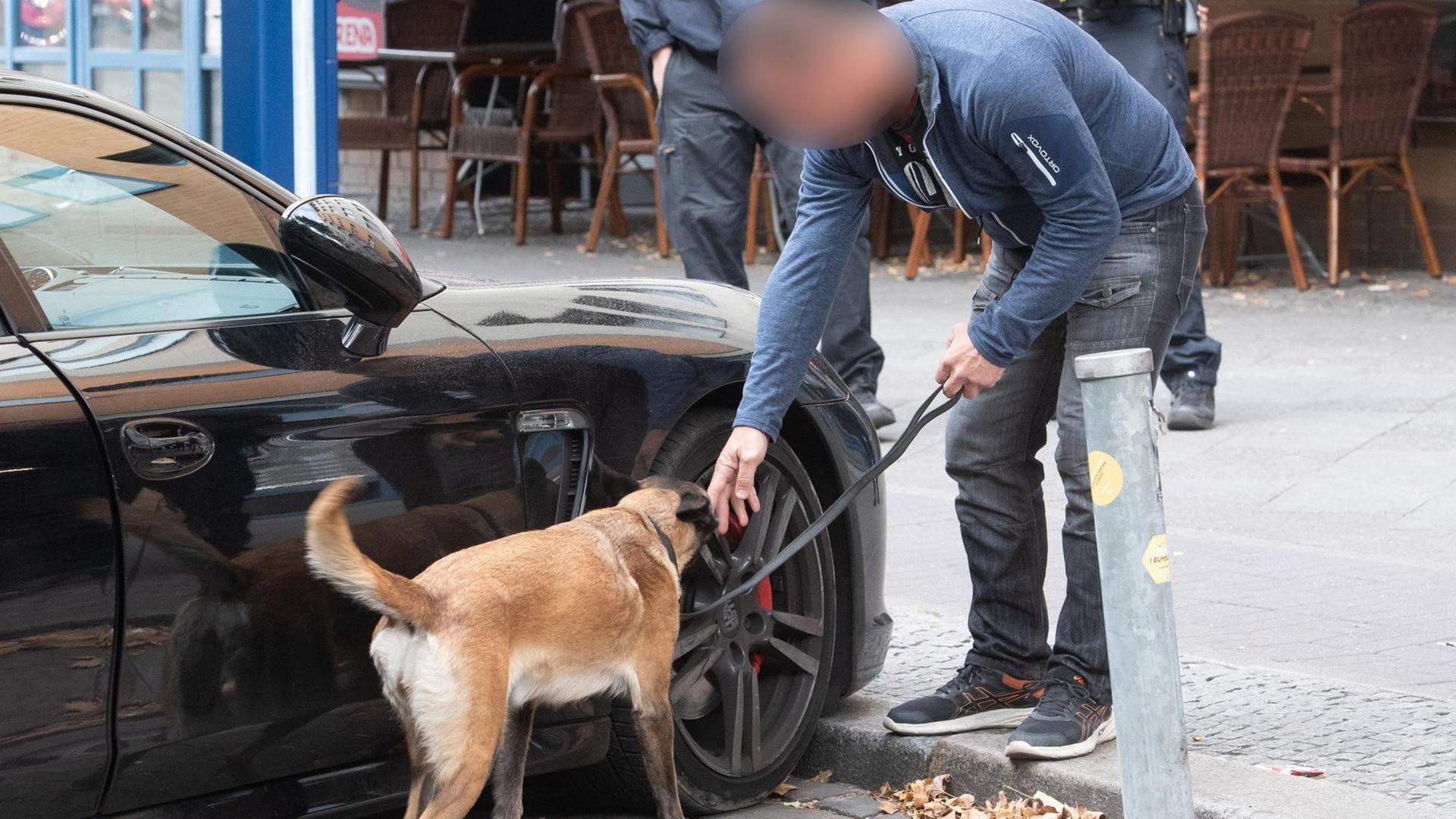 Ein Polizist untersucht mit einem Spürhund ein verdächtiges Fahrzeug. Am Montag wurde eine Razzia gegen kriminelle Mitglieder arabischer Großfamilien in Berlin durchgeführt. Ein Polizist untersucht mit einem Spürhund ein verdächtiges Fahrzeug. Am Montag wurde eine Razzia gegen kriminelle Mitglieder arabischer Großfamilien in Berlin durchgeführt.