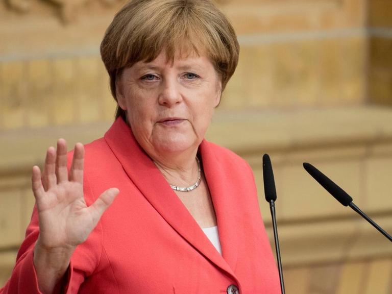 Bundeskanzlerin Angela Merkel steht an einem Rednerpult