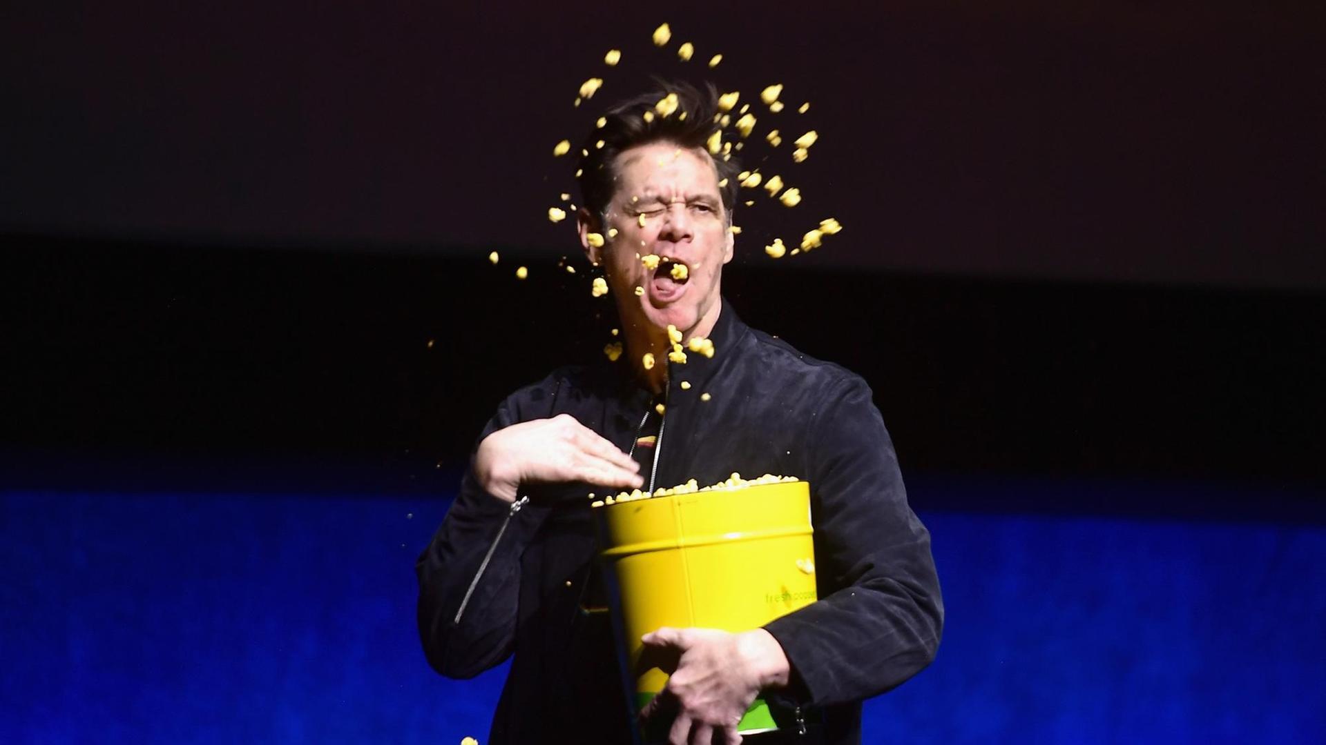 Porträt von Jim Carrey, der sich Popcorn in den Mund wirft. Porträt von Jim Carrey, der sich Popcorn in den Mund wirft.