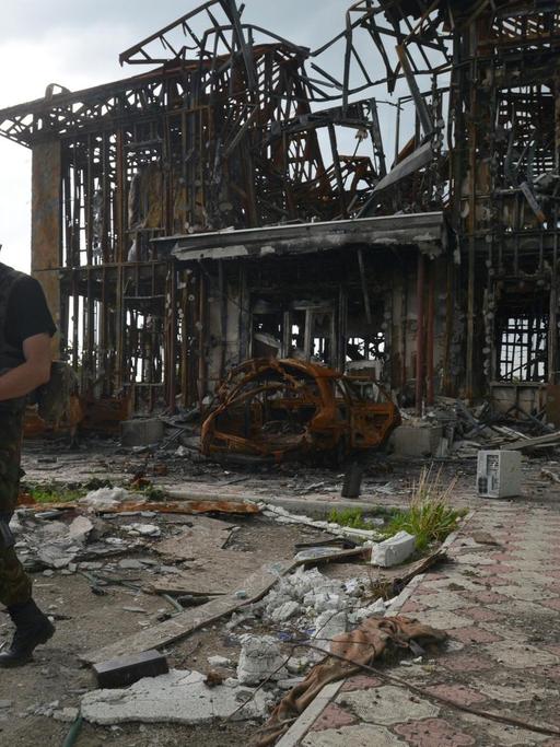 Ein ukrainischer Milizionär patroulliert vor der Ruine eines Hauses in der Nähe der Front im Osten der Ukraine