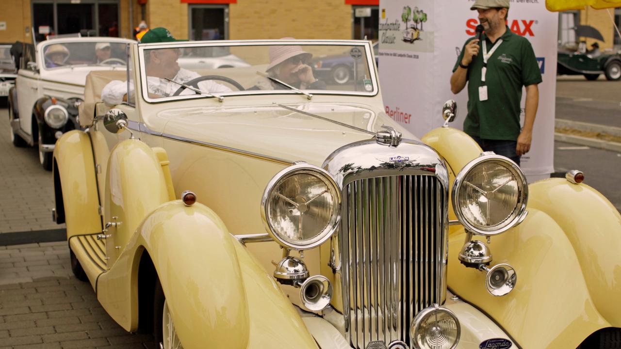 Der Autosammler Karl J. Kraus und seine Ehefrau sitzen im gut gepflegten Lagonda. Der Autosammler Karl J. Kraus und seine Ehefrau sitzen im gut gepflegten Lagonda.