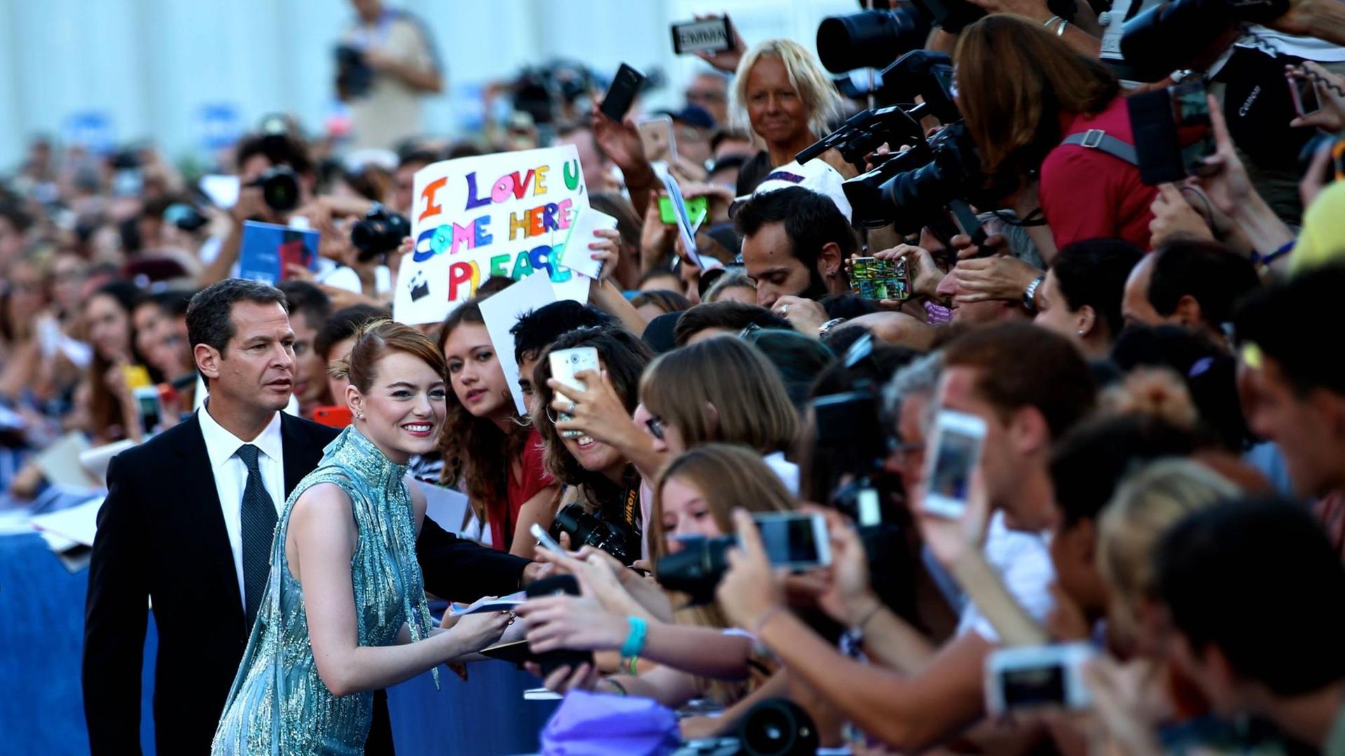 Die Schauspielerin Emma Stone wird auf dem roten Teppich von Fans umjubelt. Die Schauspielerin Emma Stone wird auf dem roten Teppich von Fans umjubelt.