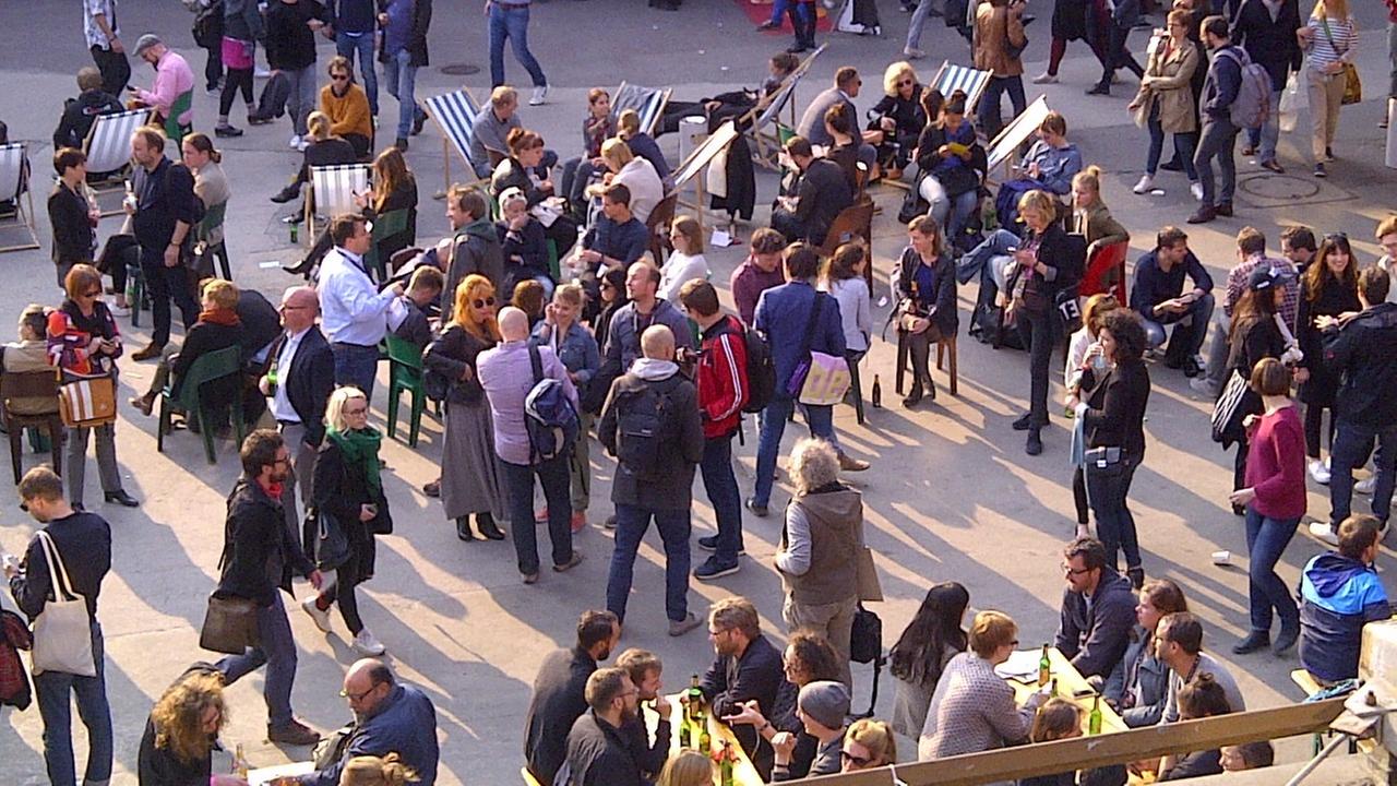 Viele Menschen stehen in der Sonne im Innenhof auf dem Geländer der republica Viele Menschen stehen in der Sonne im Innenhof auf dem Geländer der republica