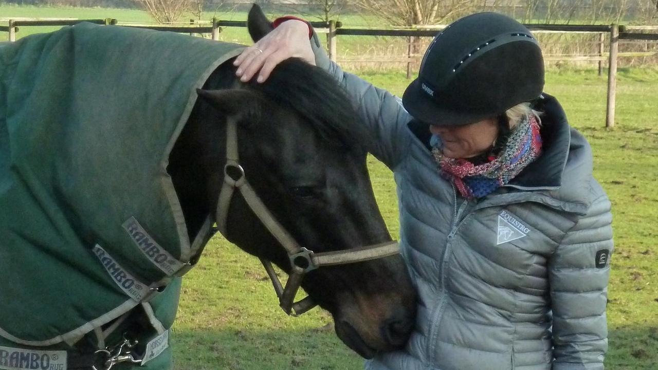 Ingrid Klimke und das Turnierpferd „Braxxi“ auf der Koppel. Ingrid Klimke und das Turnierpferd „Braxxi“ auf der Koppel.