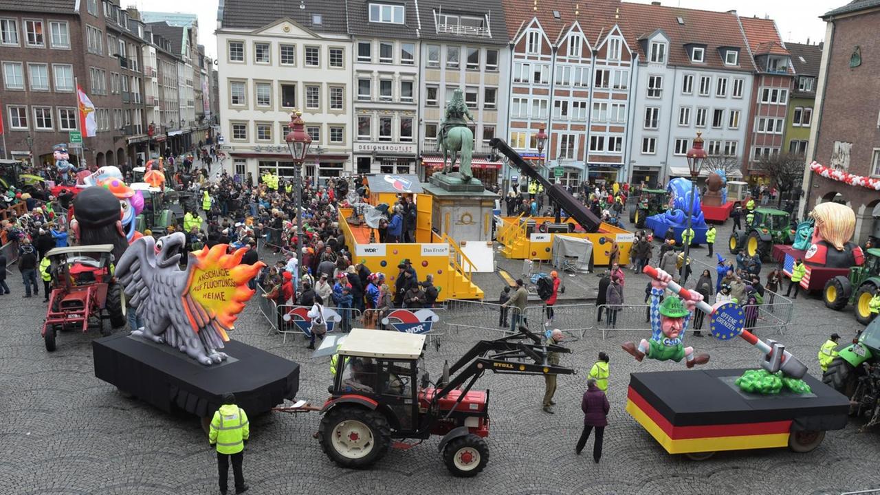 Man sieht den Düsseldorfer Rathausplatz, darauf stehen zahlreiche Trecker und Motivwagen des ausgefallenen Rosenmontagsumzuges. Man sieht den Düsseldorfer Rathausplatz, darauf stehen zahlreiche Trecker und Motivwagen des ausgefallenen Rosenmontagsumzuges.