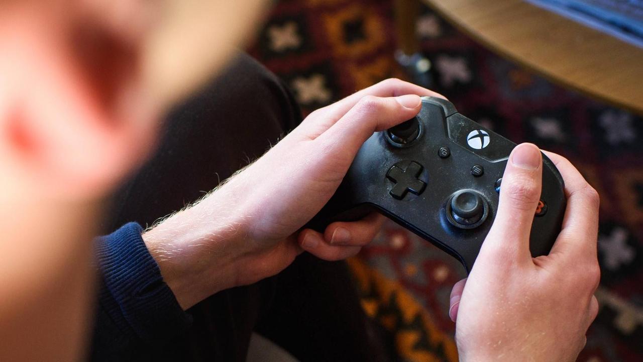 Ein Spieler hält einen XBox-Controller. Ein Spieler hält einen XBox-Controller.