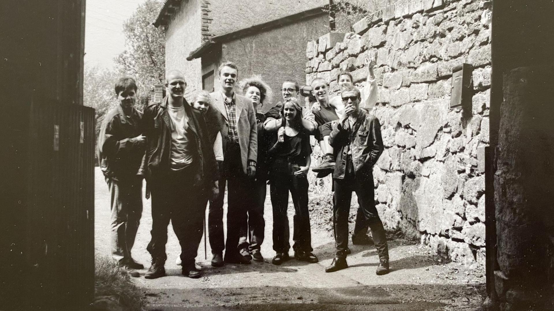 Schwarzweiß Aufnahme einer Gruppe die in einem Torbogen steht. Schwarzweiß Aufnahme einer Gruppe die in einem Torbogen steht.