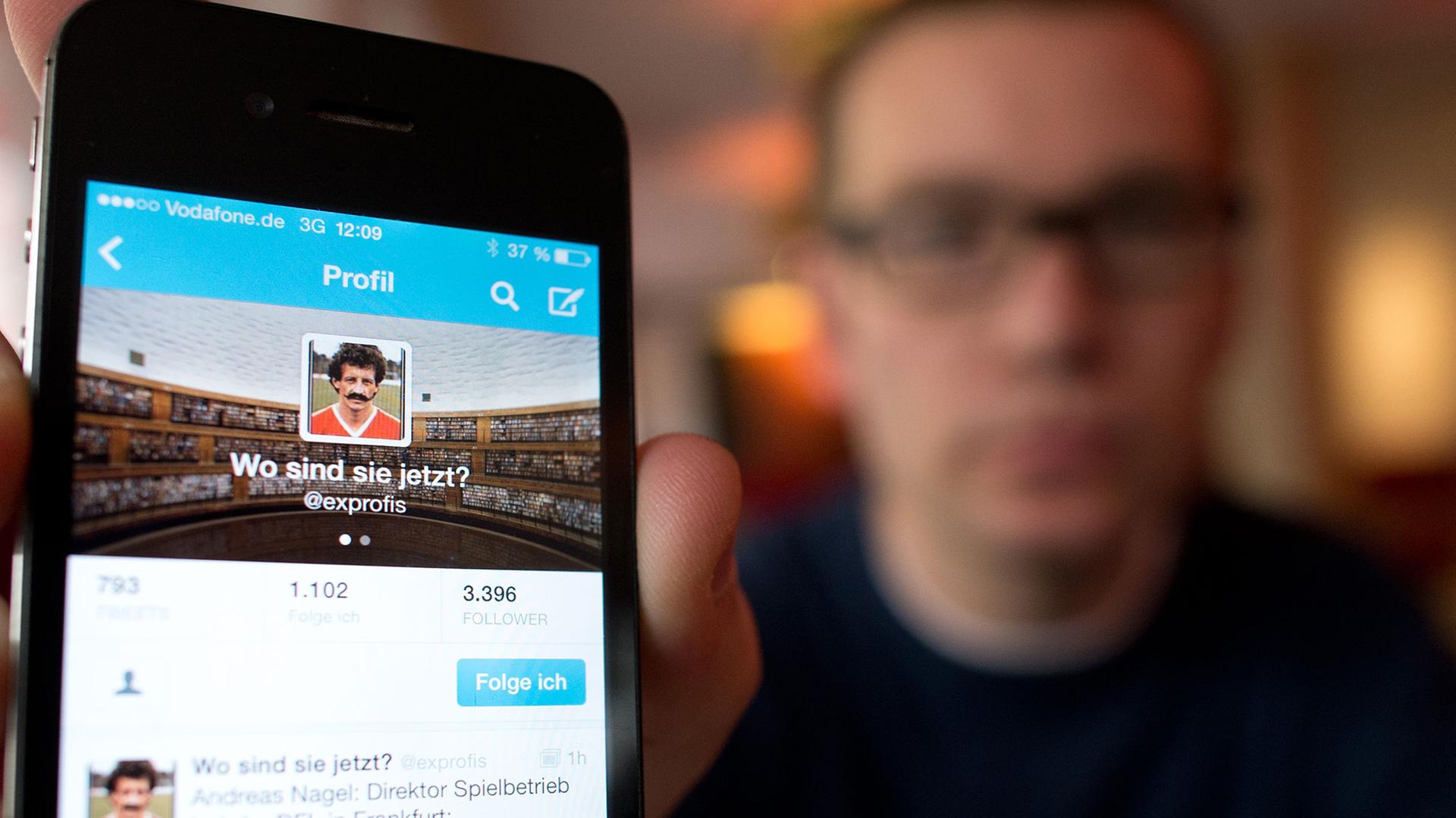Ein Journalist hält ein Smartphone hoch. Ein Journalist hält ein Smartphone hoch.