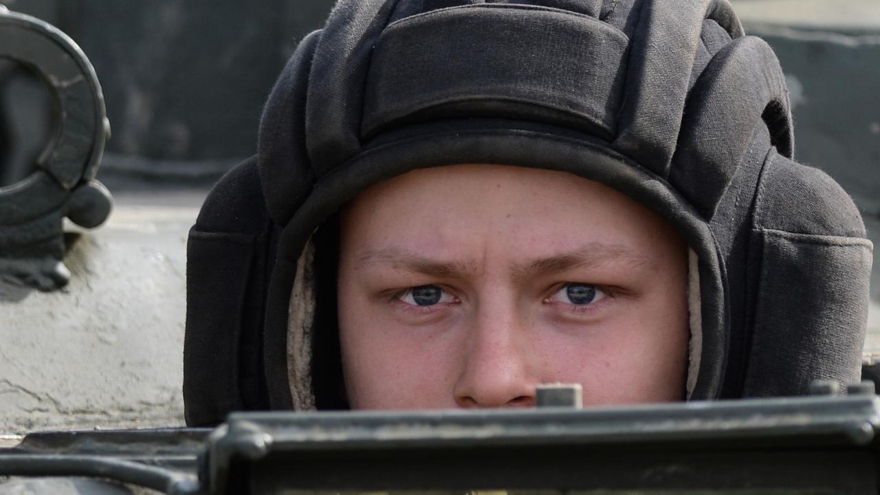 Ein russischer Soldat schaut aus einem Panzerfahrzeug Ein russischer Soldat schaut aus einem Panzerfahrzeug