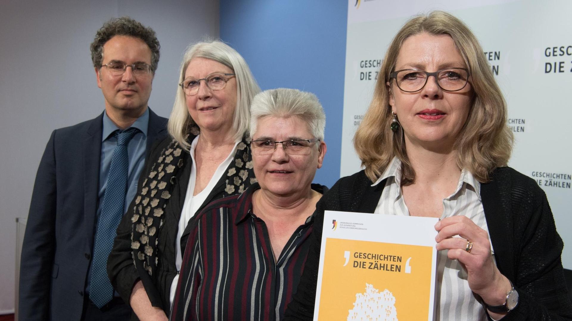 Von links nach rechts: Peer Briken und Brigitte Tilmann aus der Aufarbeitungskommssion, Hjördis E. Wirth vom Betroffenenrat und die Kommissionsvorsitzende Sabine Andresen. Andresen hält ein Exemplar des Berichts in die Kamera. Von links nach rechts: Peer Briken und Brigitte Tilmann aus der Aufarbeitungskommssion, Hjördis E. Wirth vom Betroffenenrat und die Kommissionsvorsitzende Sabine Andresen. Andresen hält ein Exemplar des Berichts in die Kamera.