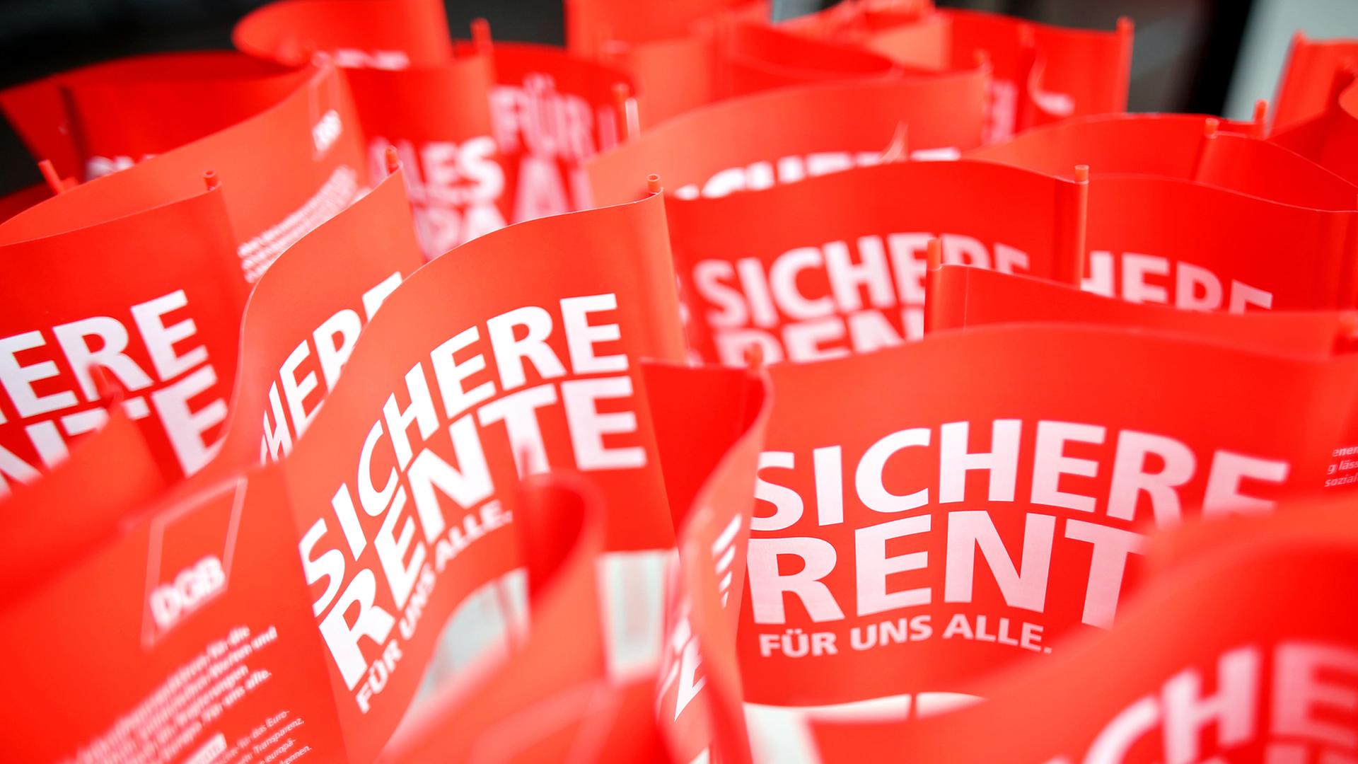 Fähnchen "Sichere Rente für uns alle!" stehen am Rande der traditionellen 1. Mai-Demo am 01.05.2014 auf einer Bühne in Leipzig (Sachsen).