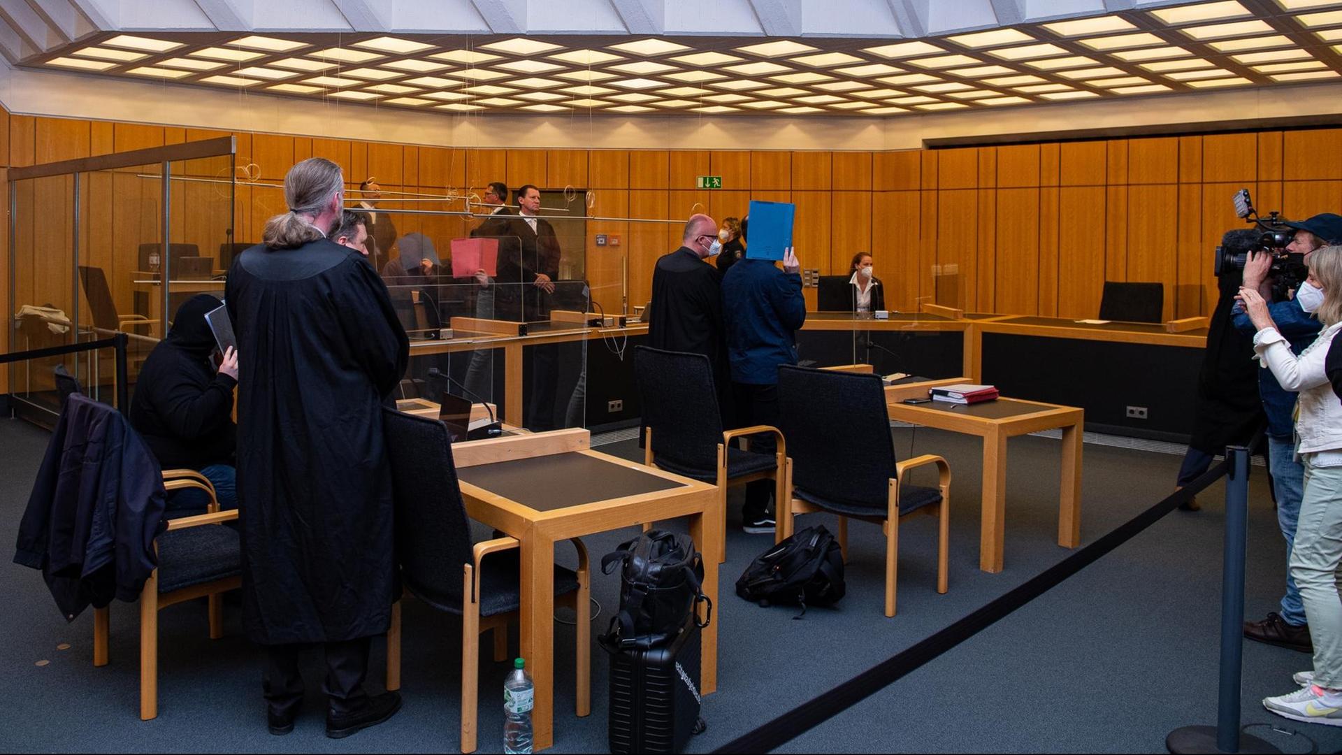 Die angeklagten Männer haben ihre Gesichter versteckt. Die angeklagten Männer haben ihre Gesichter versteckt.