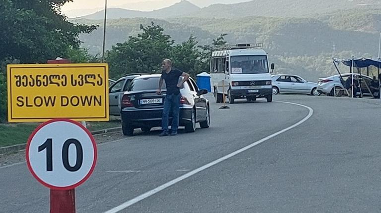 Kontrollpunkt beim Protestcamp mit Polizei im Hintergrund.