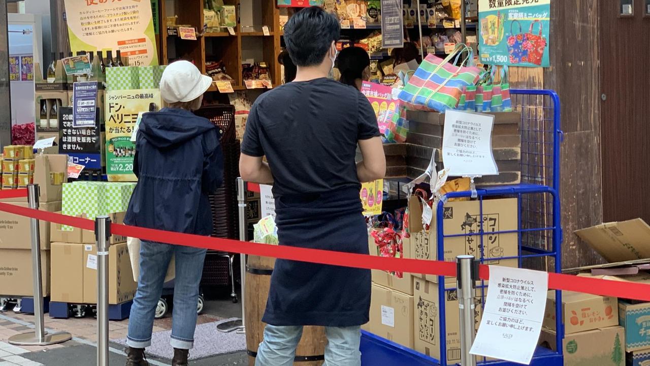 Kunden stehen in Abstand vor einem Laden in Tokio, Japan Kunden stehen in Abstand vor einem Laden in Tokio, Japan