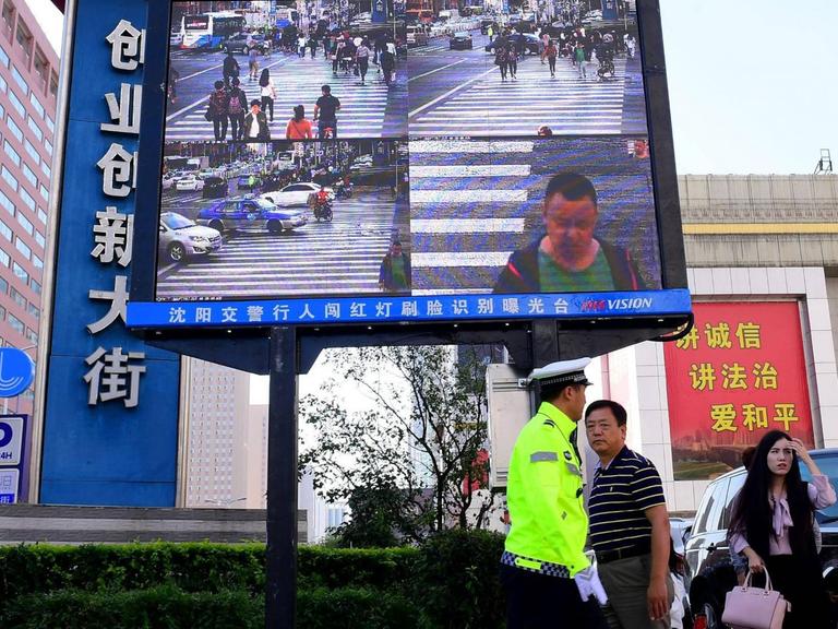 Ein Gesichtserkennungssystem in China. Es wird verwendet, um Fußgänger daran zu hindern, bei einer roten Ampel die Straße zu betreten. 