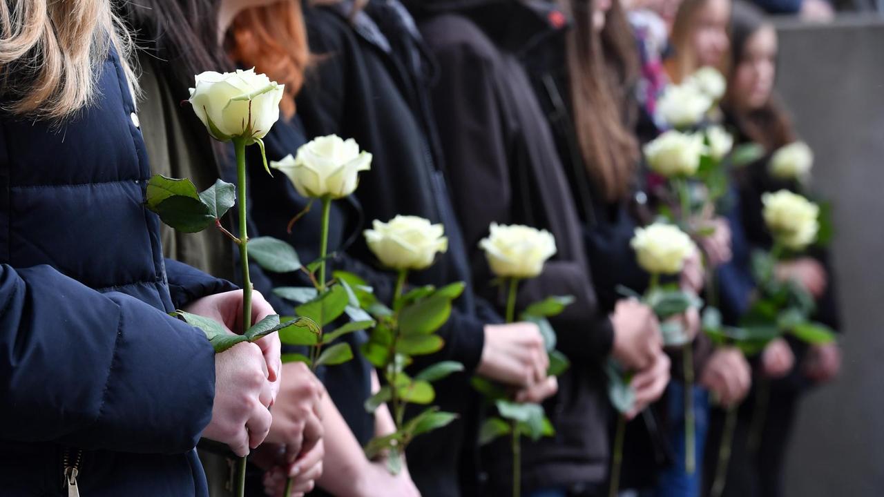 Bei einer Gedenkfeier vor dem Gutenberg-Gymnasium halten Schüler am 26.04.2017 in Erfurt (Thüringen) weiße Rosen in den Händen. 15 Jahre nach dem Amoklauf am Gutenberg-Gymnasium in Erfurt haben Schüler, Lehrer und Angehörige der Opfer gedacht. Mehrere hundert Menschen erinnerten an die zwölf Lehrer, zwei Schüler, die Sekretärin und den Polizisten, die bei der Tat getötet wurden. Bei einer Gedenkfeier vor dem Gutenberg-Gymnasium halten Schüler am 26.04.2017 in Erfurt (Thüringen) weiße Rosen in den Händen. 15 Jahre nach dem Amoklauf am Gutenberg-Gymnasium in Erfurt haben Schüler, Lehrer und Angehörige der Opfer gedacht. Mehrere hundert Menschen erinnerten an die zwölf Lehrer, zwei Schüler, die Sekretärin und den Polizisten, die bei der Tat getötet wurden.