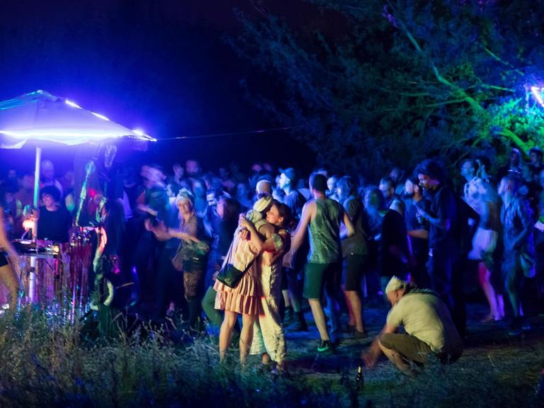 Junge Menschen feiern nachts eine Outdoor-Party in Berlin-Marzahn.