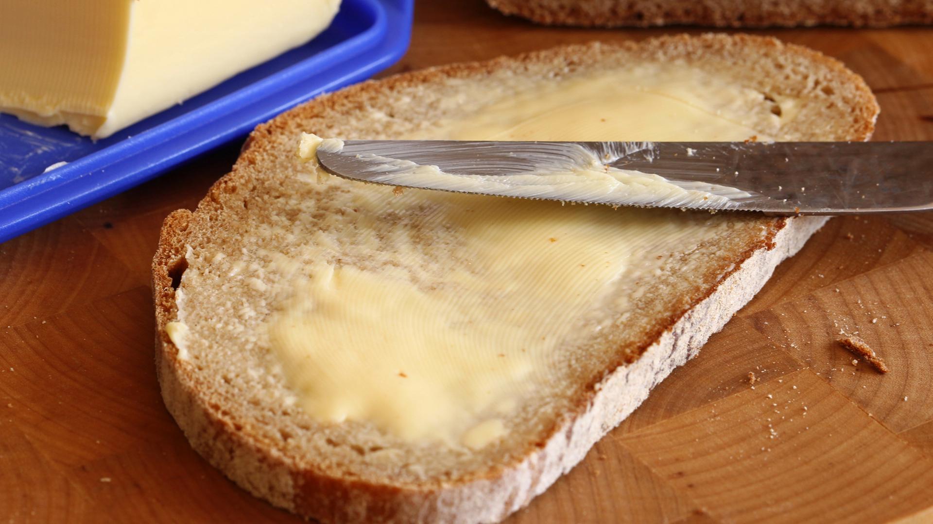 Ein Butterbrot liegt auf einem Frühstücksbrett. Ein Butterbrot liegt auf einem Frühstücksbrett.