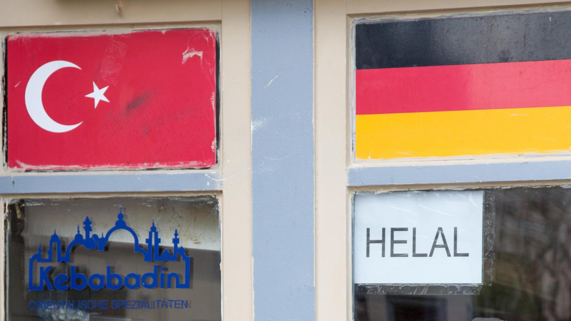 Eine türkische und eine deutsche Fahne am Fenster zu einem Imbiss. Eine türkische und eine deutsche Fahne am Fenster zu einem Imbiss.