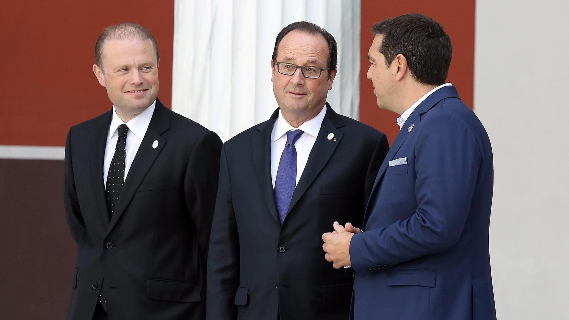Der griechische Regierungschef Alexis Tsipras (r.), Frankreichs Präsident Francois Hollande (M.) und Maltas Premierminister Joseph Muscat (l.) scherzen auf dem Weg zu einem gemeinsamen Foto beim Südeuropa-Gipfel in Athen.