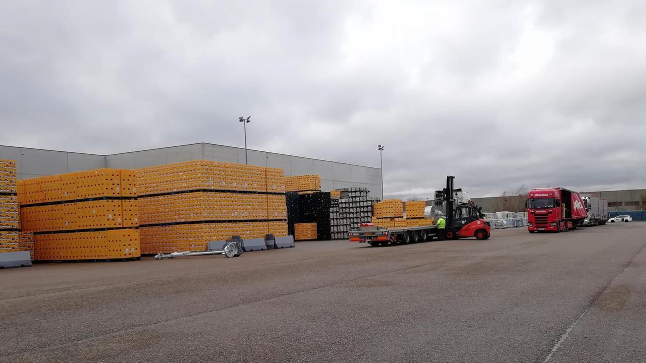 Hunderter gelber Bierkästen auf dem Parkplatz des belgischen Logistikunternehmens Vincen Logistics