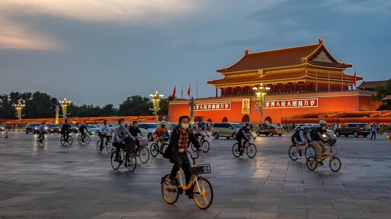 Das tägliche Leben in Peking: Fahrradfahrer und Autos auf dem erleuchteten Tian’anmen-Platz in Peking, China. Das tägliche Leben in Peking: Fahrradfahrer und Autos auf dem erleuchteten Tian’anmen-Platz in Peking, China.