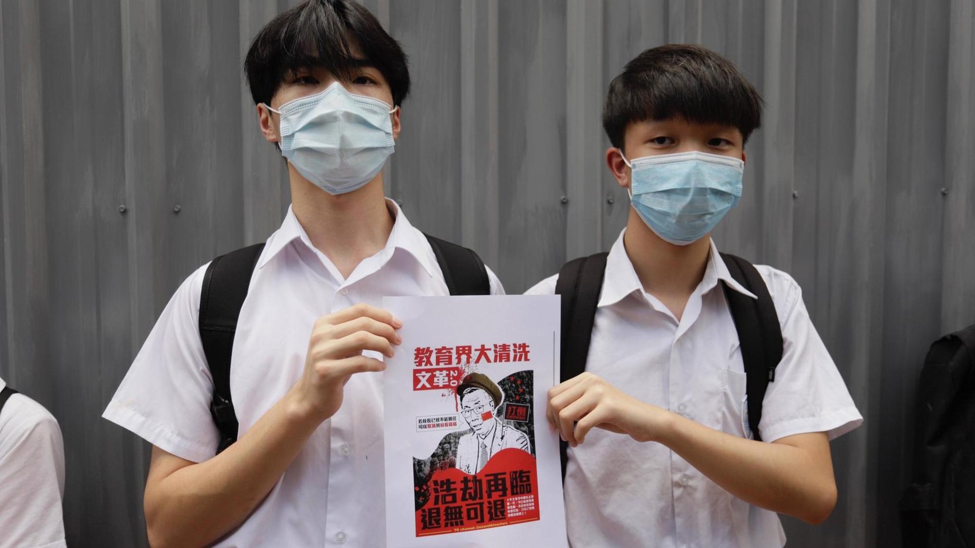 June 12, 2020, Hong Kong, CHINA: Male students displaying a small poster outside HEUNG TO MIDDLE SCHOOL, a traditionally pro-Beijing leftist school. On the poster is written : HUGE PURGE AMONG THE ACADEMIES, CULTURE REVOLUTION NO.2, CATASTROPHE HAD RETURED, THERE IS NO ROOM FOR RETREATING. June-12,2020 Hong Kong.ZUMA/ Hong Kong CHINA - ZUMAl137 20200612zapl137008 Copyright: xLiauxChung-renx