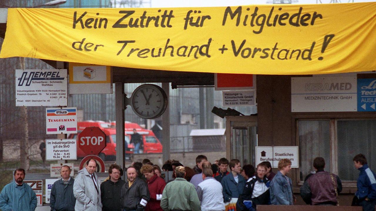 Am 1. April 1992 hindert die Belegschaft der Hermsdorfer Tridelta AG Mitarbeiter der Treuhandanstalt am Betreten des Werksgeländes. Knapp 1500 Beschäftigte protestieren so gegen die Privatisierungspolitik der Treuhandanstalt und fordern die Übernahme des angeschlagenen Unternehmens durch die von Lothar Späth geführt Jenoptik. Am 1. April 1992 hindert die Belegschaft der Hermsdorfer Tridelta AG Mitarbeiter der Treuhandanstalt am Betreten des Werksgeländes. Knapp 1500 Beschäftigte protestieren so gegen die Privatisierungspolitik der Treuhandanstalt und fordern die Übernahme des angeschlagenen Unternehmens durch die von Lothar Späth geführt Jenoptik.