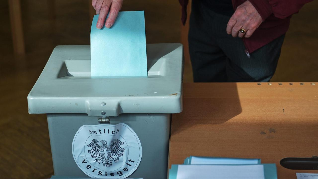 Ein Stimmzettel wird in einem Wahllokal im österreichischen Wien in eine Urne geworfen.