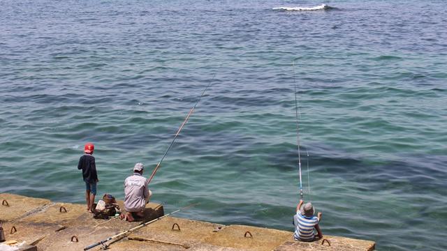 Drei Jungen angeln am Mittelmeer in Ägypten