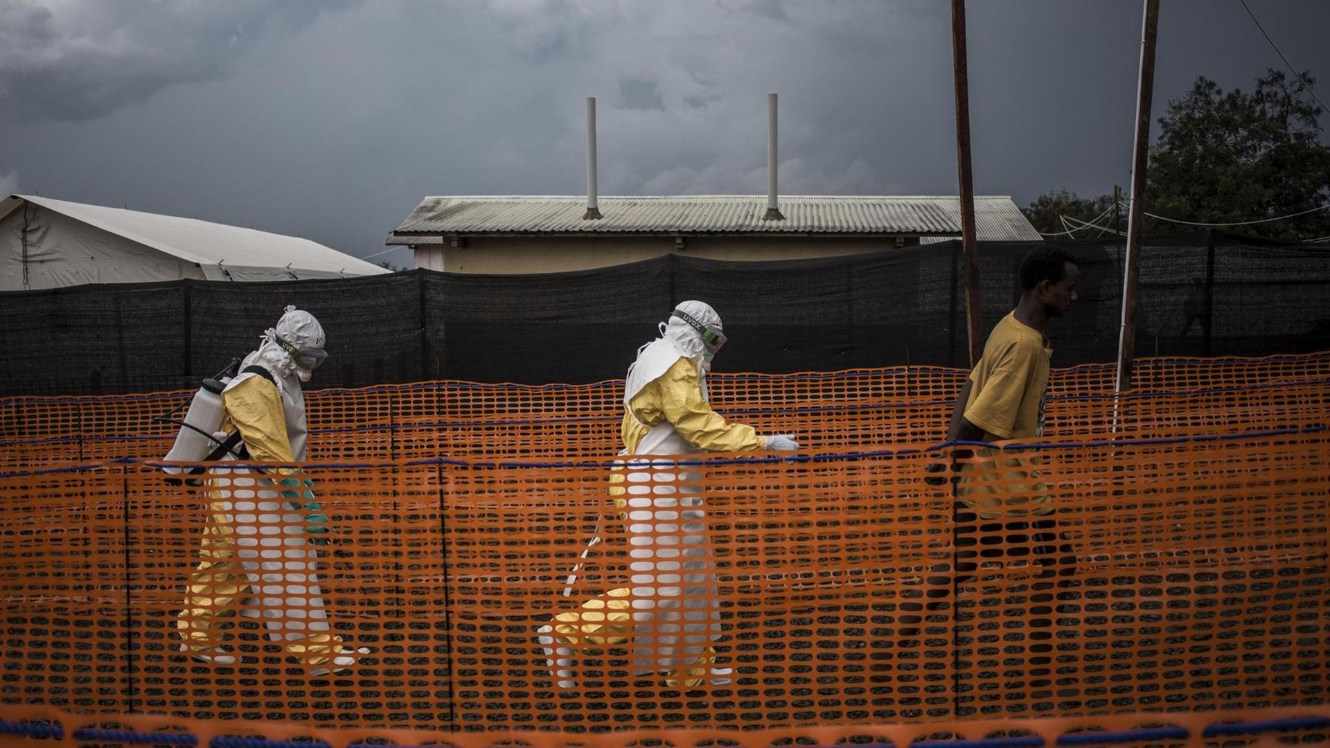 Mitarbeiter von Ärzte ohne Grenzen eskortieren einen Patienten mit Verdacht auf Ebola-Erkrankung in einem Behandlungszentrum in Bunia in der Democratischen Republik Kongo | (Photo by John WESSELS / AFP) Mitarbeiter von Ärzte ohne Grenzen eskortieren einen Patienten mit Verdacht auf Ebola-Erkrankung in einem Behandlungszentrum in Bunia in der Democratischen Republik Kongo | (Photo by John WESSELS / AFP)