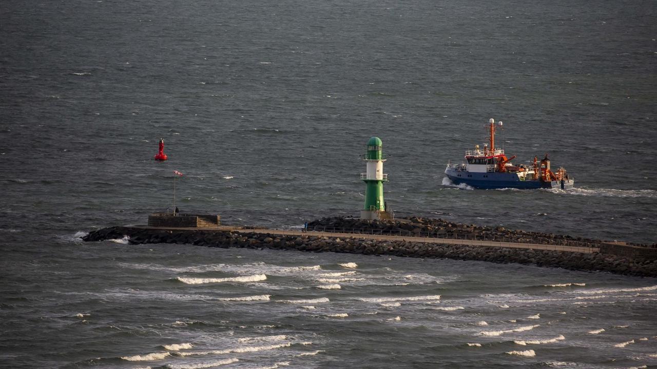 Das Fischereiforschungsschiff Clupea und das grün-weiße Westmolenfeuer in Warnemuende. Das Fischereiforschungsschiff Clupea und das grün-weiße Westmolenfeuer in Warnemuende.