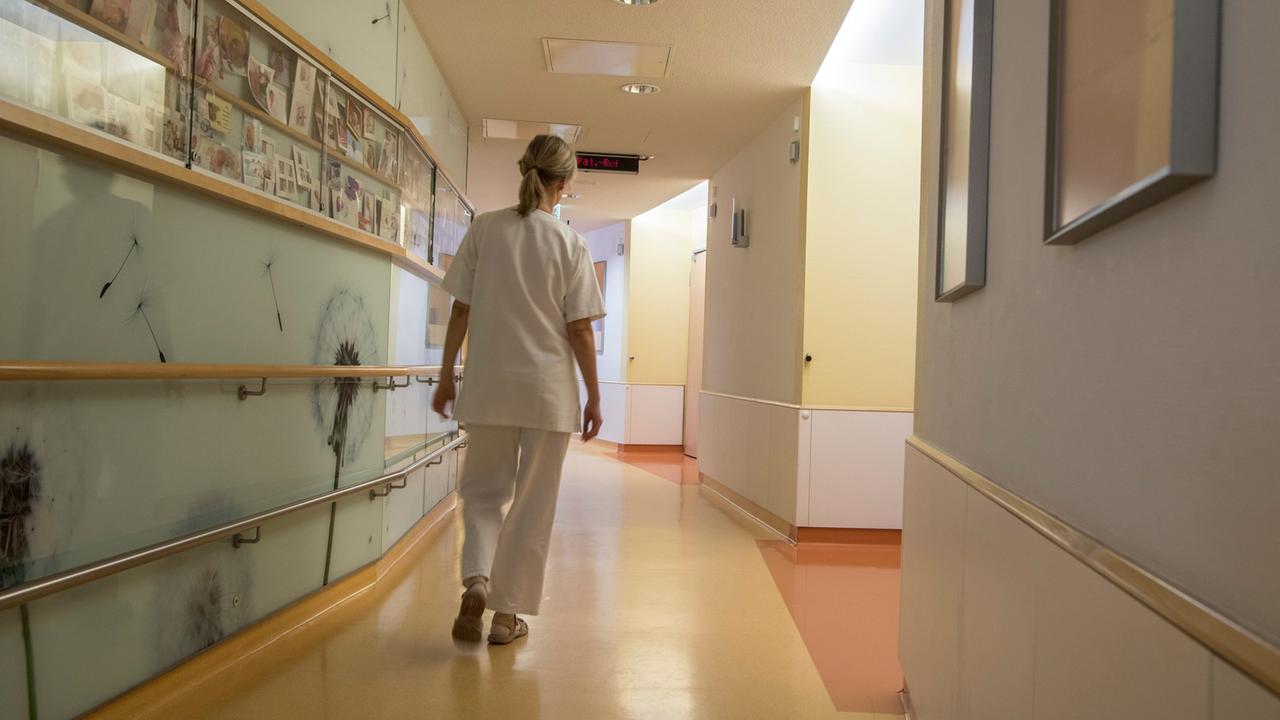 Eine Krankenschwester geht über den ansonsten leeren Flur einer Neugeborenen-Station. Eine Krankenschwester geht über den ansonsten leeren Flur einer Neugeborenen-Station.