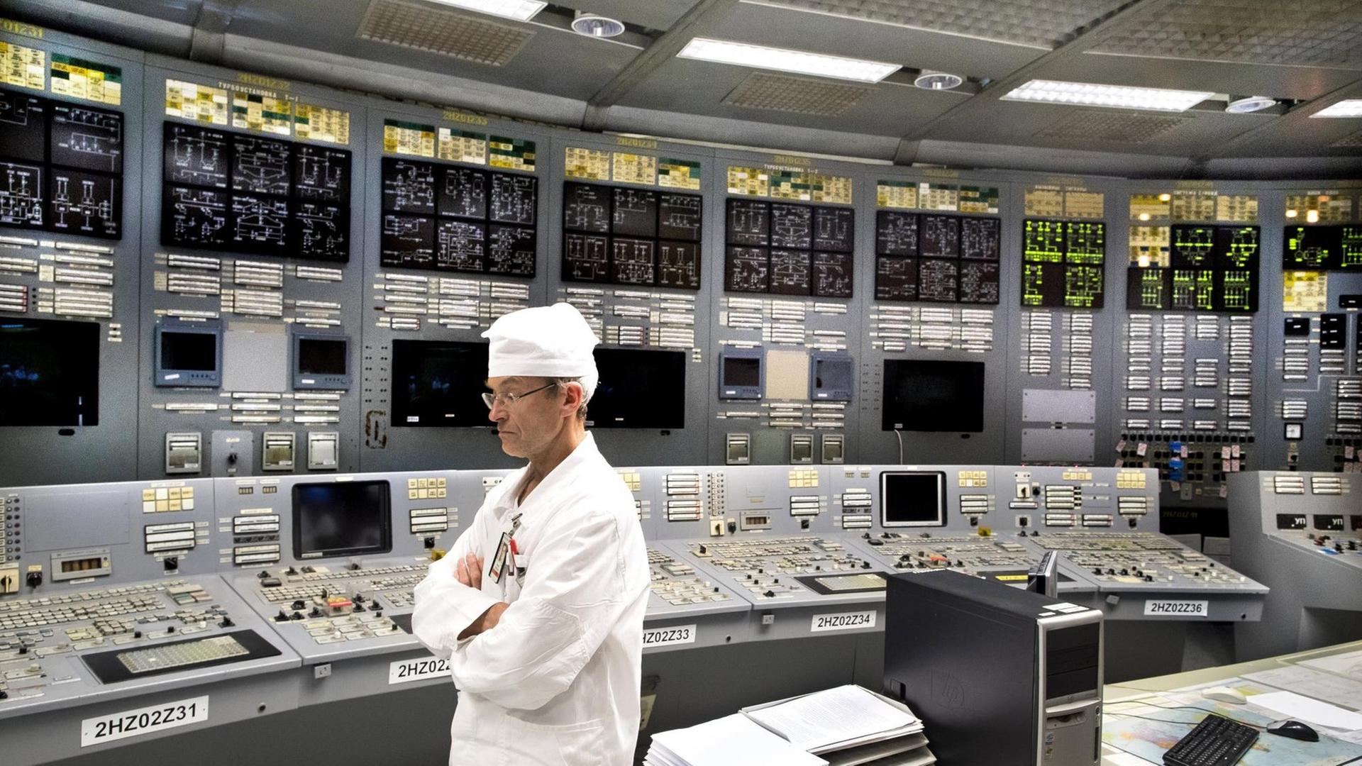 Ein Ingenieur steht im Kontrollraum des Atomkraftwerks in Visaginas vor leuchtenden Kontrollpaneelen. Ein Ingenieur steht im Kontrollraum des Atomkraftwerks in Visaginas vor leuchtenden Kontrollpaneelen.