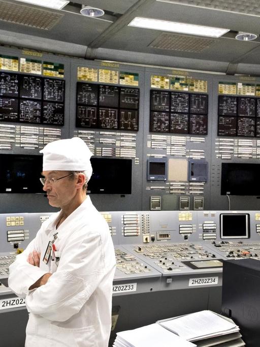Ein Ingenieur steht im Kontrollraum des Atomkraftwerks in Visaginas vor leuchtenden Kontrollpaneelen.
