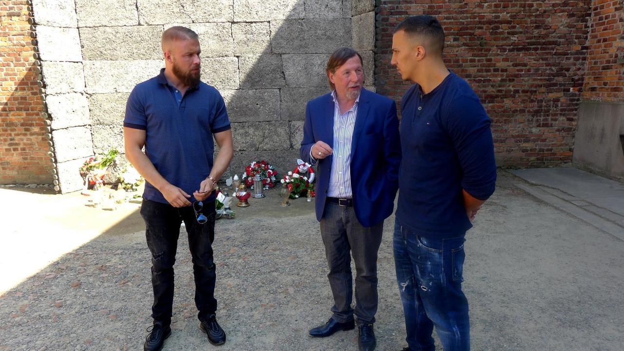 Christoph Heubner (M), Vizepräsident des Internationalen Auschwitz Komitees, spricht mit den Rappern Kollegah (l) und Farid Bang nach der Niederlegung eines Blumengebindes an der Todeswand in der KZ-Gedenkstätte Auschwitz.
